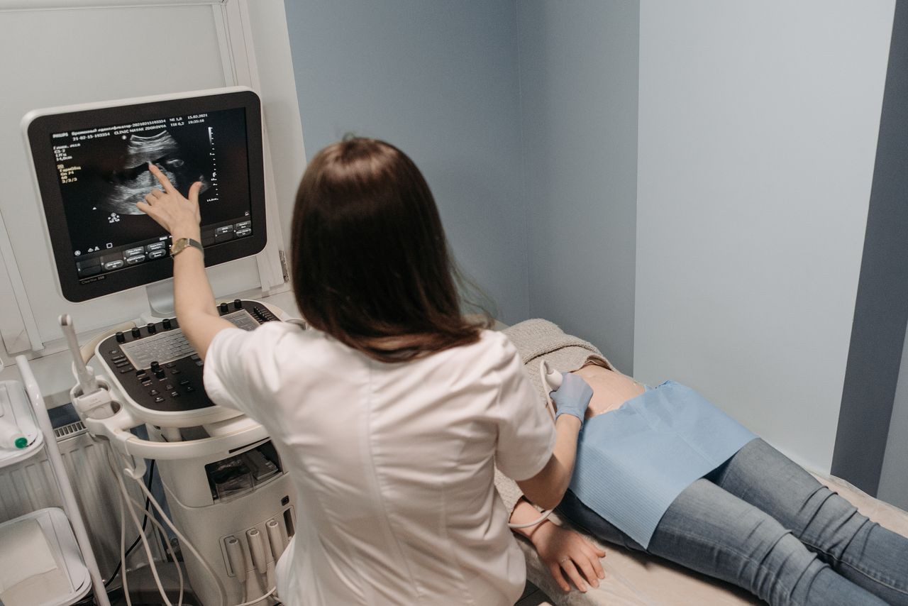 Female doctor conducting an ultrasound screening on a patient in a medical office.